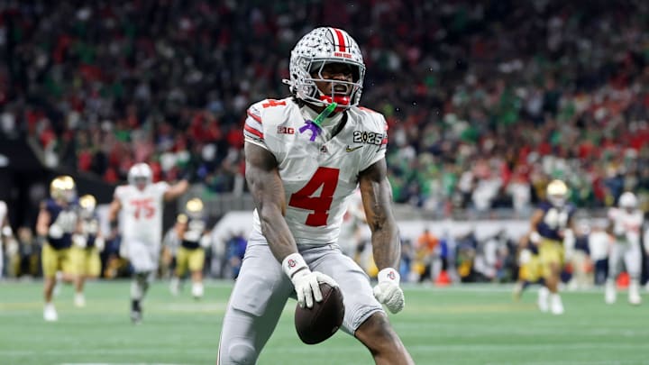 Jan 20, 2025; Atlanta, GA, USA; Ohio State Buckeyes wide receiver Jeremiah Smith (4) reacts after making a catch against the Notre Dame Fighting Irish during the second half the CFP National Championship college football game at Mercedes-Benz Stadium. Mandatory Credit: Mark J. Rebilas-Imagn Images