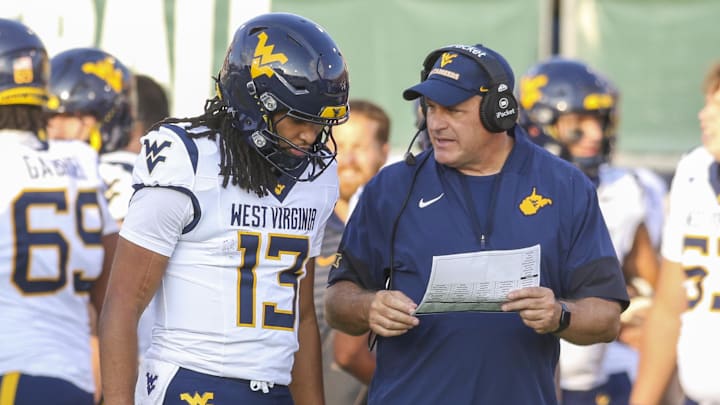 Sep 6, 2025; Athens, Ohio, USA; West Virginia Mountaineers head coach Rich Rodriguez talks with West Virginia Mountaineers quarterback Jaylen Henderson (13) during the fourth quarter against the Ohio Bobcats at Peden Stadium. Mandatory Credit: Ben Queen-Imagn Images