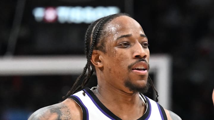 Sacramento Kings forward DeMar DeRozan slaps hands with head coach Doug Christie.