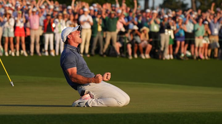 Rory McIlroy celebrates winning a playoff hole against Justin Rose to secure his first career Masters victory.