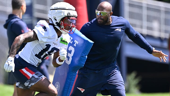 New England Patriots wide receiver Kyle Williams (18) works with a member of the coaching staff during training camp at Gillette Stadium.