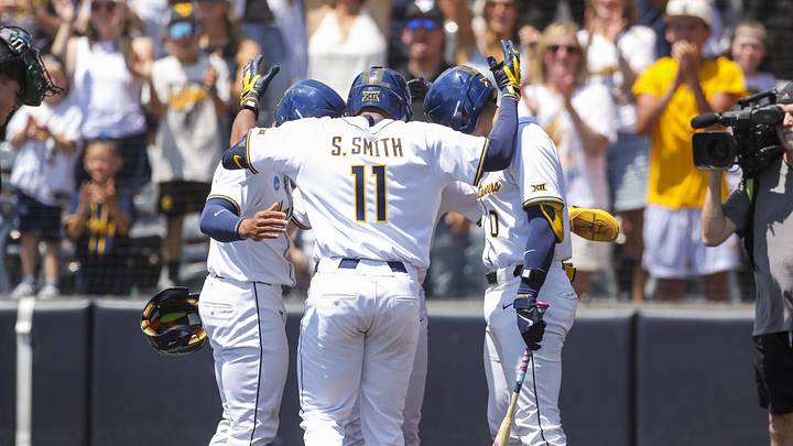 Jun 5, 2026; Morgantown, WV, USA; West Virginia Mountaineers outfielder Sean Smith (11) hits a home run and celebrates with teammates at home plate during the first inning against the Cal Poly Mustangsa at Kendrick Family Ballpark.
