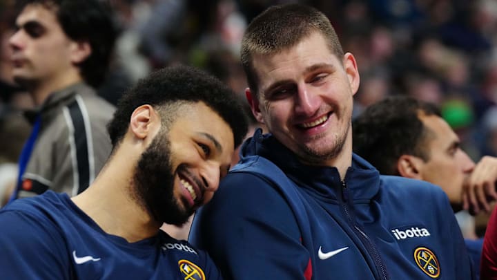 Dec 28, 2023; Denver, Colorado, USA; Denver Nuggets center Nikola Jokic (15) and guard Jamal Murray (27) react on the bench during the fourth quarter against the Memphis Grizzlies at Ball Arena. Mandatory Credit: Ron Chenoy-Imagn Images