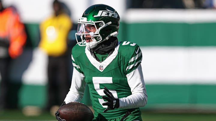 Dec 22, 2024; East Rutherford, New Jersey, USA; New York Jets wide receiver Garrett Wilson (5) gains yards after catch during the first half against the Los Angeles Rams at MetLife Stadium. Mandatory Credit: Vincent Carchietta-Imagn Images