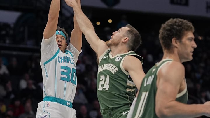 Feb 5, 2025; Charlotte, North Carolina, USA; Charlotte Hornets guard Seth Curry (30) shoots defended by Milwaukee Bucks guard Pat Connaughton (24) during the second half at Spectrum Center. Mandatory Credit: Jim Dedmon-Imagn Images