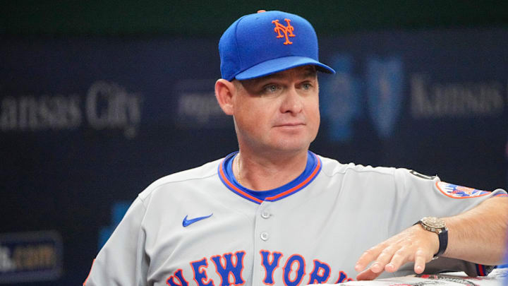 Jul 11, 2025; Kansas City, Missouri, USA; New York Mets manager Carlos Mendoza (64) watches from the dugout against the Kansas City Royals prior to a game at Kauffman Stadium. Mandatory Credit: Denny Medley-Imagn Images