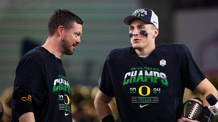 Jan 1, 2024; Glendale, AZ, USA; Oregon Ducks quarterback Bo Nix (right) celebrates with head coach Dan Lanning after defeating the Liberty Flames during the 2024 Fiesta Bowl at State Farm Stadium. Mandatory Credit: Mark J. Rebilas-USA TODAY Sports Jan 1, 2024; Glendale, AZ, USA; Oregon Ducks quarterback Bo Nix (right) celebrates with head coach Dan Lanning after defeating the Liberty Flames during the 2024 Fiesta Bowl at State Farm Stadium. Mandatory Credit: Mark J. Rebilas-USA TODAY Sports