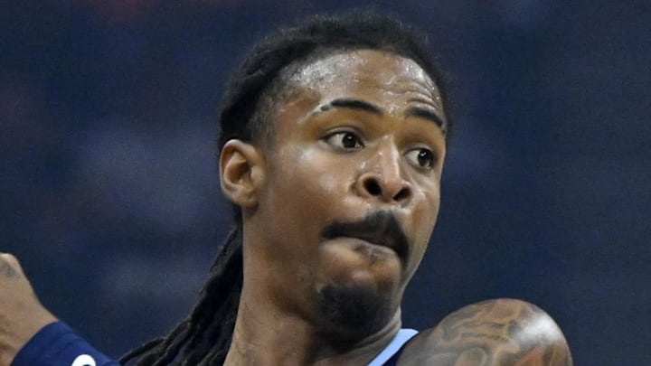 Memphis Grizzlies guard Ja Morant looks to pass beside Cleveland Cavaliers guard Sam Merrill.