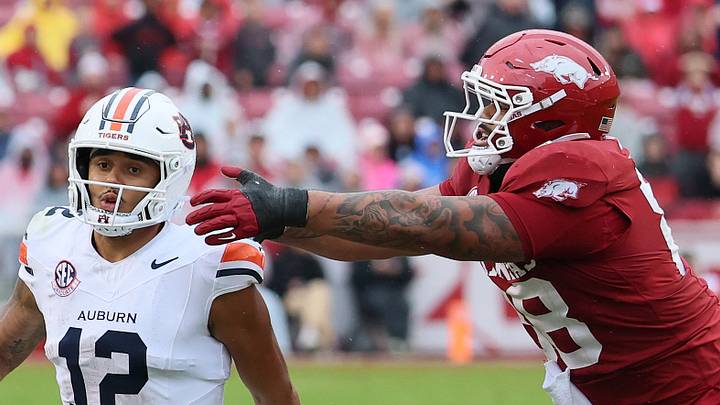 Oct 25, 2025; Fayetteville, Arkansas, USA; Auburn Tigers quarterback Ashton Daniels (12) rushes during the third quarter as Arkansas Razorbacks defensive tackle Danny Saili (88) defends at Donald W. Reynolds Razorback Stadium. Auburn won 33-24. Mandatory Credit: Nelson Chenault-Imagn Images