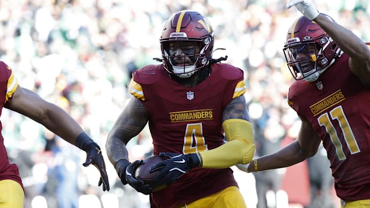 Dec 22, 2024; Landover, Maryland, USA; Washington Commanders linebacker Frankie Luvu (4) celebrates with teammates after intercepting a pass against the Philadelphia Eagles during the first quarter at Northwest Stadium. Mandatory Credit: Geoff Burke-Imagn Images