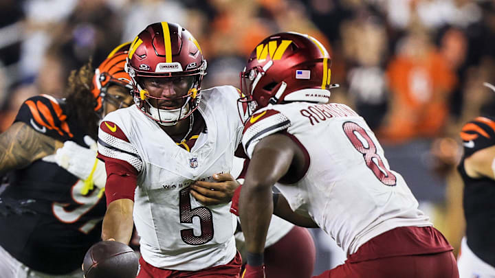 Sep 23, 2024; Cincinnati, Ohio, USA; Washington Commanders quarterback Jayden Daniels (5) hands the ball off to running back Brian Robinson Jr. (8) in the second half against the Cincinnati Bengals at Paycor Stadium. Mandatory Credit: Katie Stratman-Imagn Images