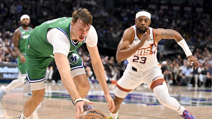 Nov 12, 2025; Dallas, Texas, USA; Dallas Mavericks forward Cooper Flagg (32) and Phoenix Suns guard Jordan Goodwin (23) chase the ball during the second quarter at the American Airlines Center. Mandatory Credit: Jerome Miron-Imagn Images