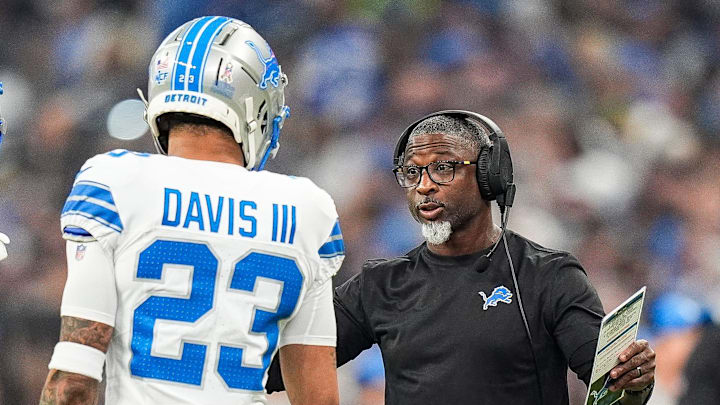 Detroit Lions defensive coordinator Aaron Glenn, right, talks to cornerback Carlton Davis III (23).
