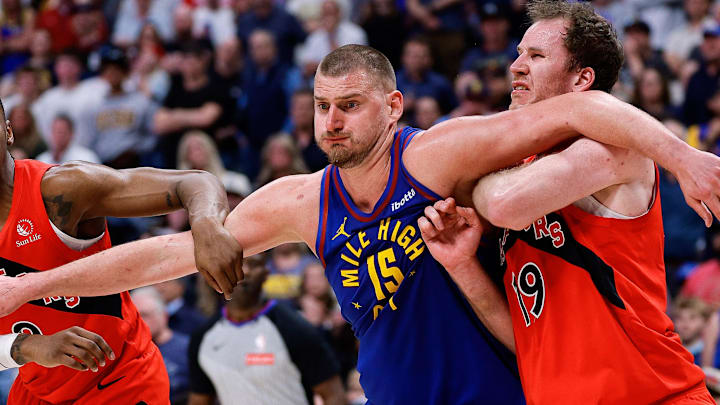 Mar 20, 2026; Denver, Colorado, USA; Denver Nuggets center Nikola Jokic (15) battles for position with Toronto Raptors forward RJ Barrett (9) and center Jakob Poeltl (19) in the fourth quarter at Ball Arena.