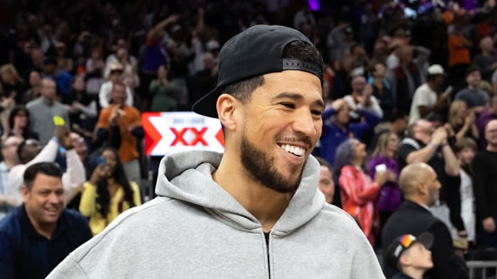 Feb 21, 2026; Phoenix, Arizona, USA; Phoenix Suns injured guard Devin Booker celebrates after defeating the Orlando Magic at Mortgage Matchup Center. Mandatory Credit: Mark J. Rebilas-Imagn Images