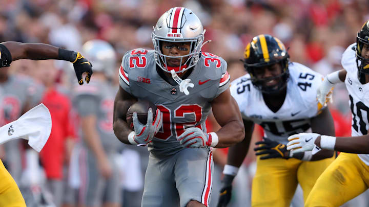 Oct 5, 2024; Columbus, Ohio, USA; Ohio State Buckeyes running back TreVeyon Henderson (32) runs the ball against Iowa Hawkeyes linebacker Nick Jackson (10) and defensive back Jermari Harris (27) during the fourth quarter at Ohio Stadium. Mandatory Credit: Joseph Maiorana-Imagn Images Oct 5, 2024; Columbus, Ohio, USA; Ohio State Buckeyes running back TreVeyon Henderson (32) runs the ball against Iowa Hawkeyes linebacker Nick Jackson (10) and defensive back Jermari Harris (27) during the fourth quarter at Ohio Stadium. Mandatory Credit: Joseph Maiorana-Imagn Images