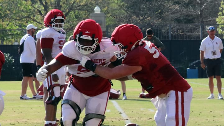Oklahoma defensive tackle James "Tank" Carrington pursues running back Gabe Sawchuk (29) during a spring practice rep.