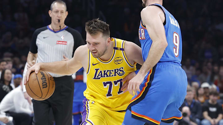 Apr 8, 2025; Oklahoma City, Oklahoma, USA; Los Angeles Lakers guard Luka Doncic (77) moves the ball down the court against Oklahoma City Thunder guard Alex Caruso (9) during the second quarter at Paycom Center. Mandatory Credit: Alonzo Adams-Imagn Images