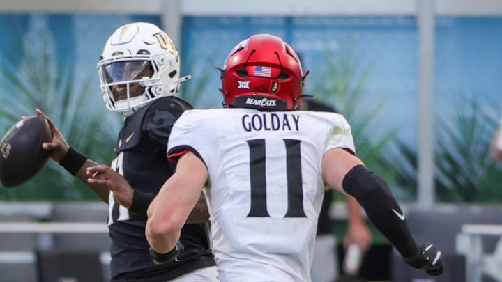 Oct 12, 2024; Orlando, Florida, USA; UCF Knights quarterback Jacurri Brown (11) looks to pass in front of Cincinnati Bearcats linebacker Jake Golday (11) during the second half at FBC Mortgage Stadium. Mandatory Credit: Mike Watters-Imagn Images