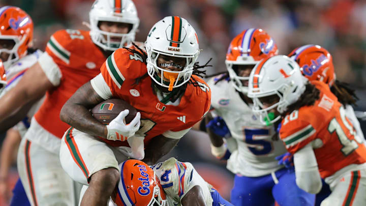 Sep 20, 2025; Miami Gardens, Florida, USA; Miami Hurricanes running back Mark Fletcher Jr. (4) carries the football against Florida Gators defensive back Jordan Castell (14) during the fourth quarter at Hard Rock Stadium. Mandatory Credit: Sam Navarro-Imagn Images Sep 20, 2025; Miami Gardens, Florida, USA; Miami Hurricanes running back Mark Fletcher Jr. (4) carries the football against Florida Gators defensive back Jordan Castell (14) during the fourth quarter at Hard Rock Stadium. Mandatory Credit: Sam Navarro-Imagn Images