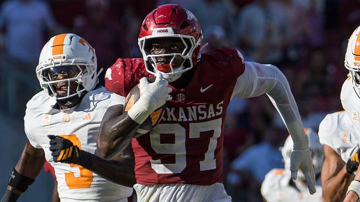 Arkansas Razorbacks defensive lineman Quincy Rhodes Jr. (97) returns an interception as Tennessee Volunteers quarterback George MacIntyre (12) and wide receiver Radarious Jackson (3) chase him during the second quarter at Razorback Stadium. Arkansas Razorbacks defensive lineman Quincy Rhodes Jr. (97) returns an interception as Tennessee Volunteers quarterback George MacIntyre (12) and wide receiver Radarious Jackson (3) chase him during the second quarter at Razorback Stadium.