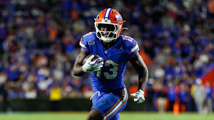 Nov 29, 2025; Gainesville, Florida, USA; Florida Gators running back Jadan Baugh (13) rushes with the ball against the Florida State Seminoles during the second half at Ben Hill Griffin Stadium. Mandatory Credit: Matt Pendleton-Imagn Images