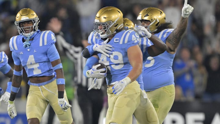 Nov 8, 2024; Pasadena, California, USA;   UCLA Bruins linebacker Carson Schwesinger (49) and teammates celebrate after an interception in the second half against the Iowa Hawkeyes at the Rose Bowl. Mandatory Credit: Jayne Kamin-Oncea-Imagn Images