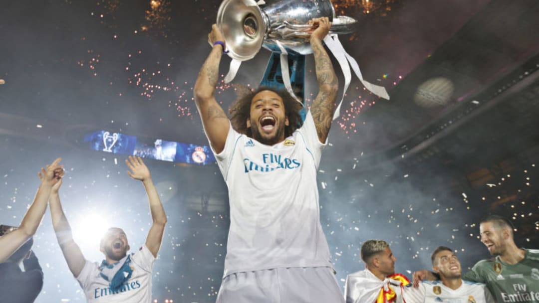 MADRID, SPAIN - MAY 27: Marcelo of Real Madrid holds up the Champions League trophy as they celebrate at Santiago Bernabeu a day after winning their 13th European Cup and UEFA Champions League Final on May 27, 2018 in Madrid, Spain. (Photo by Helios de la Rubia/Real Madrid via Getty Images)