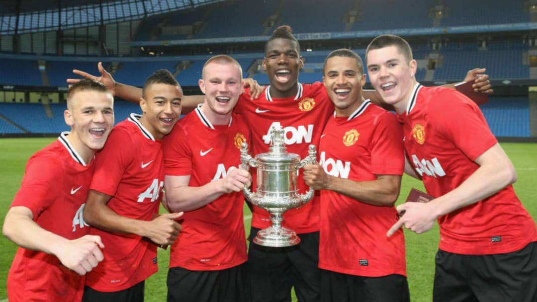 MANCHESTER, ENGLAND - MAY 17: (L-R) Luke Giverin, Jesse Lingard, Ryan Tunnicliffe, Paul Pogba, Ezekiel Fryers and Michael Keane of Manchester United Reserves celebrate with the Manchester Senior Cup trophy after the Manchester Senior Cup Final between Manchester City Reserves and Manchester United Reserves at Etihad Stadium on May 17, 2012 in Manchester, England. (Photo by John Peters/Man Utd via Getty Images)