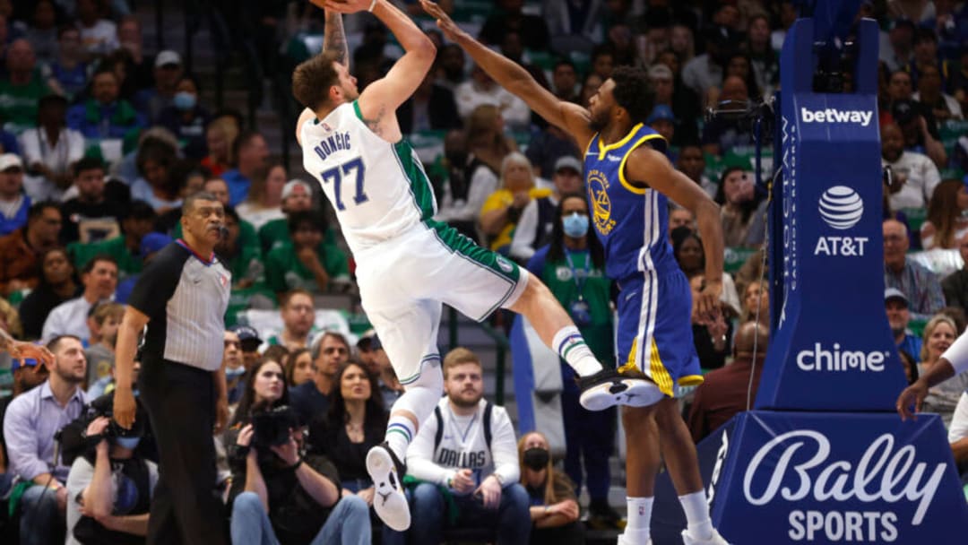 DALLAS, TX - MARCH 3: Luka Doncic #77 of the Dallas Mavericks shoots the ball as Andrew Wiggins #22 of the Golden State Warriors defends in the first half at American Airlines Center on March 3, 2022 in Dallas, Texas. NOTE TO USER: User expressly acknowledges and agrees that, by downloading and or using this photograph, User is consenting to the terms and conditions of the Getty Images License Agreement. (Photo by Ron Jenkins/Getty Images)