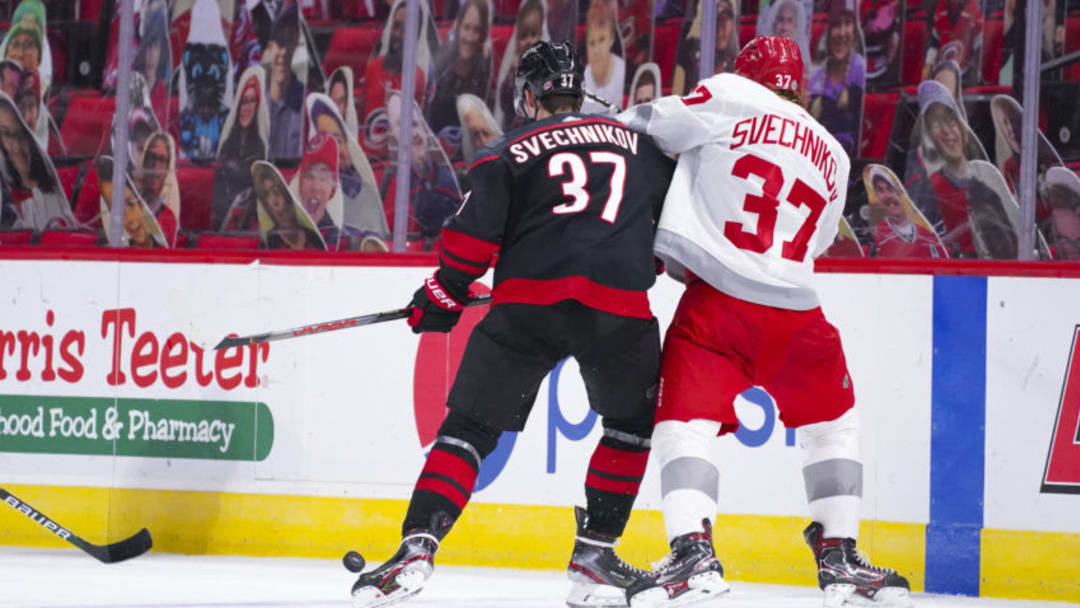 Mar 4, 2021; Raleigh, North Carolina, USA; Carolina Hurricanes right wing Andrei Svechnikov (37) and Detroit Red Wings left wing Evgeny Svechnikov (37) battle over the loose puck during the third period at PNC Arena. Mandatory Credit: James Guillory-USA TODAY Sports