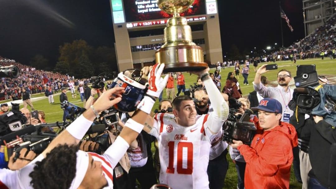 Nov 28, 2015; Starkville, MS, USA; Mississippi Rebels quarterback Chad Kelly (10) celebrates with the Egg Bowl trophy after the game against the Mississippi State Bulldogs at Davis Wade Stadium. Mississippi won 38-27. Mandatory Credit: Matt Bush-USA TODAY Sports