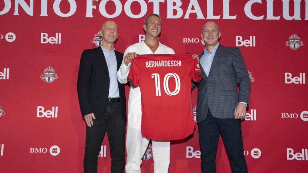 Toronto FC player Federico Bernardeschi holds a Toronto FC jersey while flanked by Toronto FC coach Bob Bradley left and Toronto FC president Bill Manning. Nick Turchiaro-USA TODAY Sports