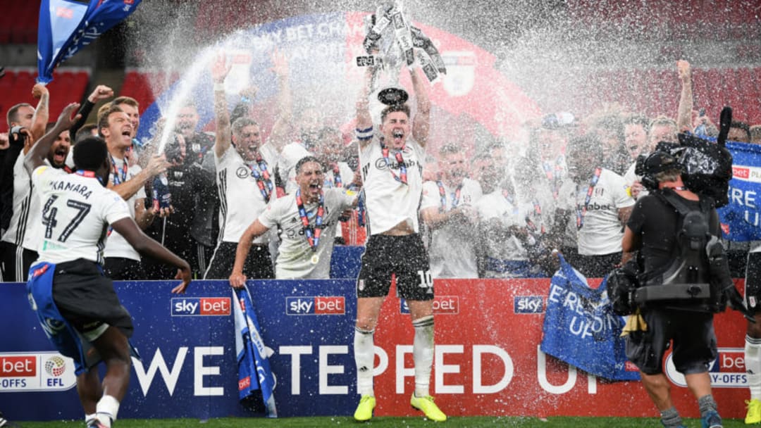 LONDON, ENGLAND - AUGUST 04: Tom Cairney of Fulham lifts the trophy as the team celebrate victory after the Sky Bet Championship Play Off Final match between Brentford and Fulham at Wembley Stadium on August 04, 2020 in London, England. Football Stadiums around Europe remain empty due to the Coronavirus Pandemic as Government social distancing laws prohibit fans inside venues resulting in all fixtures being played behind closed doors. (Photo by Shaun Botterill/Getty Images)