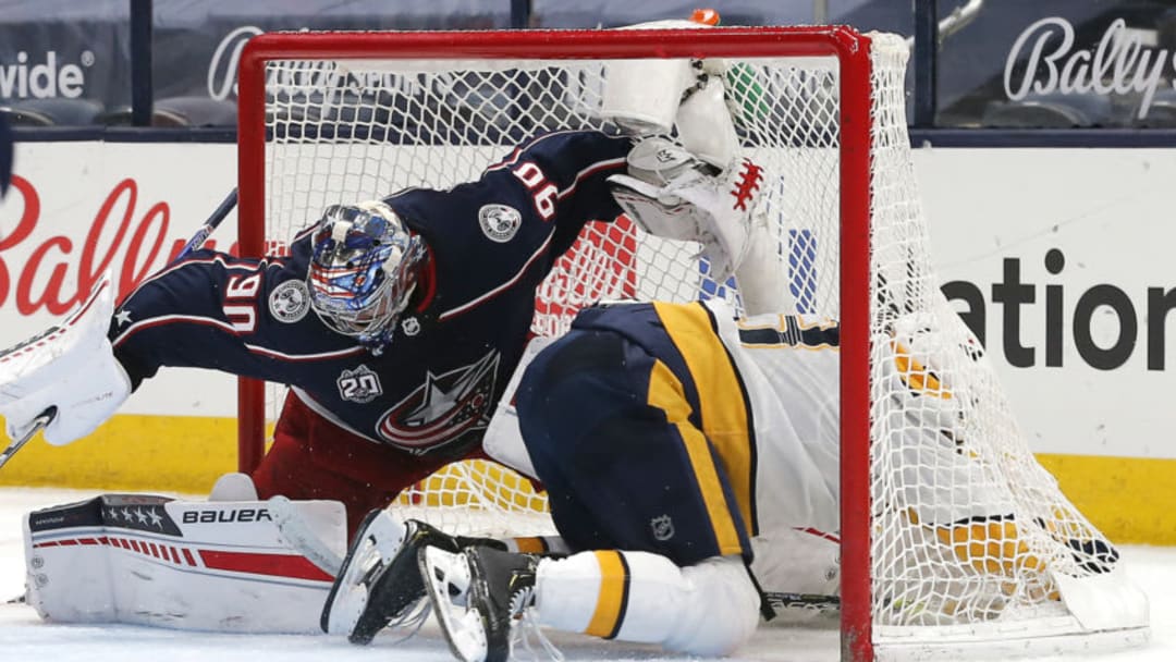May 5, 2021; Columbus, Ohio, USA; Columbus Blue Jackets goalie Elvis Merzlikins (90) makes a save as Nashville Predators center Yakov Trenin (13) crashes into net during the second period at Nationwide Arena. Mandatory Credit: Russell LaBounty-USA TODAY Sports