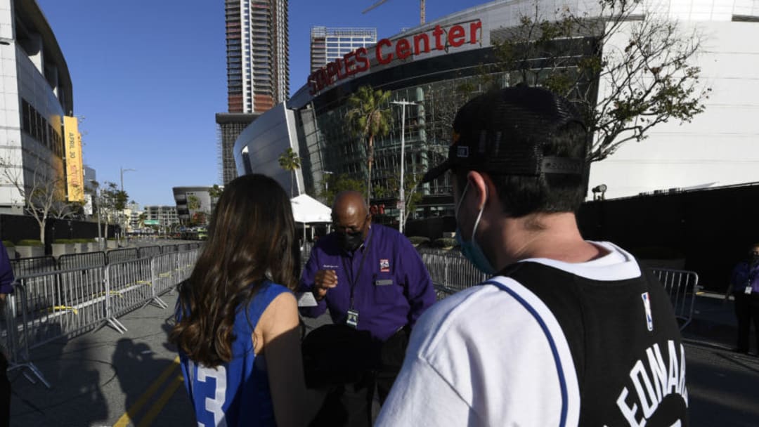 LOS ANGELES, CA - APRIL 18: An usher check the vaccination card of a Los Angeles Clippers fan as they attend for the first time over a year a basketball game between Los Angeles Clippers and Minnesota Timberwolves at Staples Center on April 18, 2021 in Los Angeles, California. NOTE TO USER: User expressly acknowledges and agrees that, by downloading and or using this photograph, User is consenting to the terms and conditions of the Getty Images License Agreement. (Photo by Kevork Djansezian/Getty Images)
