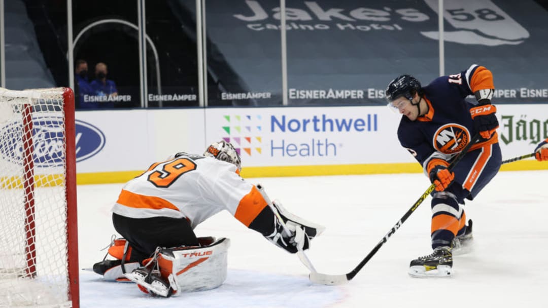 UNIONDALE, NEW YORK - MARCH 20: Mathew Barzal #13 of the New York Islanders shoots against Carter Hart #79 of the Philadelphia Flyers during their game at Nassau Coliseum on March 20, 2021 in Uniondale, New York. (Photo by Al Bello/Getty Images)