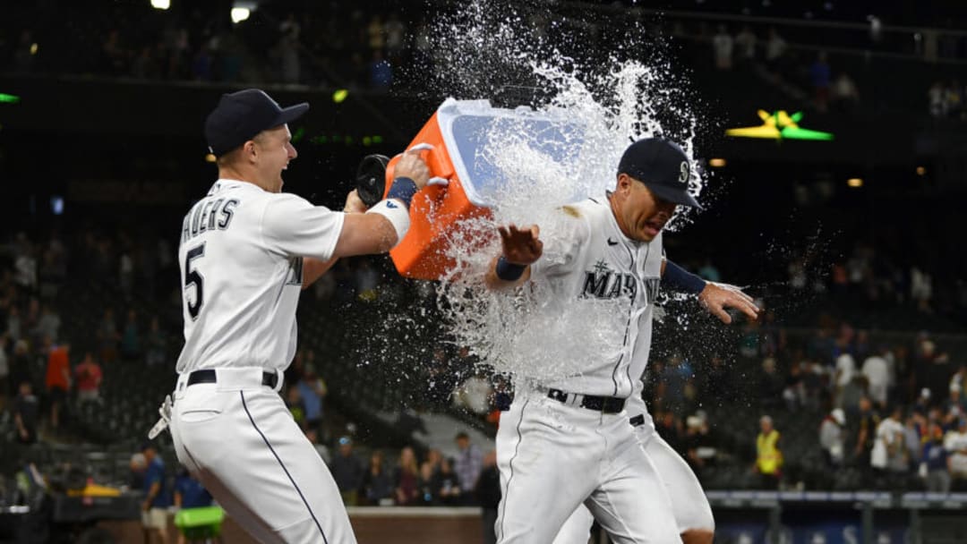 SEATTLE, WASHINGTON - JULY 26: Dylan Moore #25 of the Seattle Mariners gets a Gatorade bath from Jake Bauers #5 and Ty France #23 after the game against the Houston Astros at T-Mobile Park on July 26, 2021 in Seattle, Washington. (Photo by Alika Jenner/Getty Images)