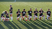 Chicago Red Stars players kneel during the national anthem.