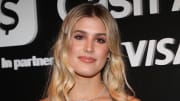 Genie Bouchard wears her blonde hair in a soft curl and sports a pink glossy lip and a diamond necklace.