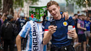 A Scotland supporter speaks with an England supporter before...