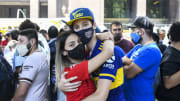 Una pareja de River y Boca se abraza en el funeral de Maradona.