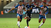Jugadores de Chivas pelean un balón ante un futbolista de Querétaro.