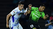 Roberto Alvarado (Cruz Azul) y Carlos Rosel (Bravos) compiten por el esférico en el Guard1anes 2021.
