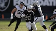 Oakland Raiders running back Josh Jacobs bursting through the hole vs. the Jacksonville Jaguars