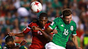 Héctor Herrera pelea un balón por los aires ante Kevan George.