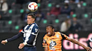 Jugadores de Pachuca y de Rayados de Monterrey pelean un balón.