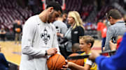 New Orleans Pelicans PG Lonzo Ball signs a basketball for a young fan.