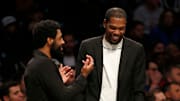 Kevin Durant (R) talking with Kyrie Irving (L) on the Nets' bench