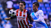 Antonio Briseño de Chivas cubriendo la pelota del chileno Pablo Parra de Puebla.